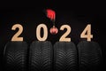 Winter car tires, new year 2024 quality wheels and hand of mechanic man with with holiday christmas ball on background Royalty Free Stock Photo