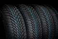 Winter car tires in row isolated on black Royalty Free Stock Photo