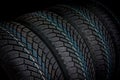 Winter car tires in row isolated on black Royalty Free Stock Photo