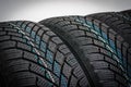 Winter car tires in row isolated on gray Royalty Free Stock Photo