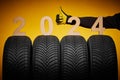 Winter car tires service and thumb up hand of mechanic and text 2024 happy new year on yellow background Royalty Free Stock Photo