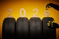 Winter car tires service and thumbs up hands of mechanic and text 2024 happy new year on black background Royalty Free Stock Photo