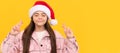 Winter child isolated portrait. dreamy kid in santa claus hat crossed fingers for luck on yellow background, holidays