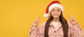 Winter child isolated portrait. dreamy kid in santa claus hat crossed fingers for luck on yellow background, holidays