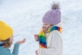 Winter children blow snow. Happy kids friends having fun, playing at winter walk outdoors. Royalty Free Stock Photo