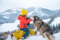 Winter children with Husky dog in the snow. Siberian husky with blue eyes in winter forest, Austria or Canada.