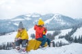 Winter children travellers enjoy coffee time with scenery view of the snowy mountain background. Kids in snow drink tea. Royalty Free Stock Photo