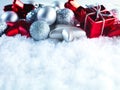 Winter and Christmas background. Beautiful sparkling silver and red Christmas decoration on a white snow background. Royalty Free Stock Photo