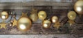 Winter christmas background. Gold baubles decorations, over old wooden plank. Top view. Banner. Royalty Free Stock Photo