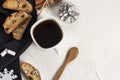 Winter Christmas composition. A cup of coffee on a white table with a black napkin with Italian traditional biscotti cookies and Royalty Free Stock Photo