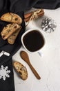 Winter Christmas composition. A cup of coffee on a white table with a black napkin with Italian traditional biscotti cookies and Royalty Free Stock Photo