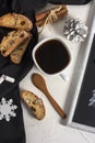 Winter Christmas composition. A cup of coffee on a white table with a black napkin with Italian traditional biscotti cookies and Royalty Free Stock Photo
