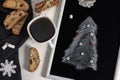 Winter Christmas composition. A cup of coffee on a white table with a black napkin with Italian traditional biscotti cookies and Royalty Free Stock Photo