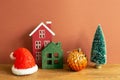 Winter christmas concept. Santa claus hat, house model, bauble, tree on wooden table Royalty Free Stock Photo