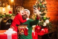 Winter Christmas emotion. Little Santa and old bearded Santa using smartphone. Internet, wireless and social media