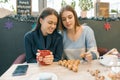 Women in cafe drink hot drinks, lay on the table walnuts in shape of Christmas tree