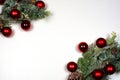 Winter, Christmas and New Year composition from two green frosty pine branches with cones and red shiny and matte Christmas balls
