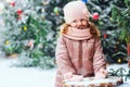 Winter and christmas portrait of happy baby girl walking outdoor in snowy day, city decorated for holidays Royalty Free Stock Photo