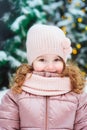 Winter and christmas portrait of happy baby girl walking outdoor in snowy day, city decorated for holidays Royalty Free Stock Photo