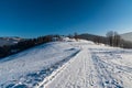 Winter on Cienkow in Beskid Slaski mountains in Poland  with snow covered road and meadows, trees, hills on the background and Royalty Free Stock Photo