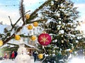 Winter city Christmas tree illuminated ,snowman and pine branch with gold confetti and red ball ,people walk ,snowy Tallinn old to