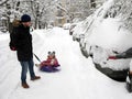 Winter, city, dad and cheerful child on a sled