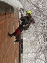 winter climber drilling the wall of the house against the background of snow-covered trees