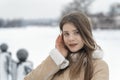 Winter close-up portrait of beautiful girl with daytime makeup in warm beige sheepskin coat in outdoors. Young woman Royalty Free Stock Photo