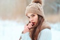 winter close up portrait of beautiful young woman in knitted hat and sweater walking in snowy park Royalty Free Stock Photo