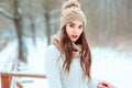 Close up winter portrait of dreamy young woman walking in snowy forest