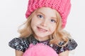 Winter clothes. Portrait of little curly girl in knitted pink winter hat Royalty Free Stock Photo