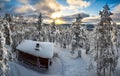 Winter cloudy panoramic landscape with forest, trees covered snow, a lonely cottage and sunray coming through the clouds Royalty Free Stock Photo