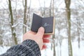 Winter or cold idea. Hand holding a book with the inscription Brr the background of the snowy forest Royalty Free Stock Photo