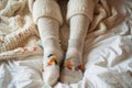 Winter comfort legs in leggings and wool socks peeking from blanket