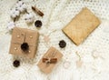 Winter composition with an old book, gifts, pine cones, cinnamon, a cotton branch on a light knitted blanket. Flat lay