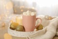 Winter concept with cup coffee with marshmallow and blurred lights