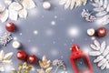 Winter concept flat lay with golden and silver leaves and red candles with snow falling. Christmas frame background Royalty Free Stock Photo