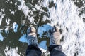 In winter Concept Man wear hiking boots standing on a frozen ice rive covered snow Royalty Free Stock Photo