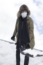 Winter Concepts. Workaholic Caucasian Handsome Man in Protective Facial Mask Throwing Away Snow With Broken Shovel In City