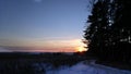 Winter country dirt and gravel road in forest and field