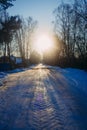 Winter countryside's landscape presented by icy snowy road, trees and houses Royalty Free Stock Photo