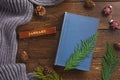 Winter, cozy composition. Warm plaid, book and christmas decoration, on wooden background Royalty Free Stock Photo