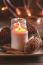 Winter cozy decoration with white burning candles on a wooden  festive table and blurrred lights Royalty Free Stock Photo