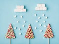 Winter creative sweet composition concept. Three hard caramel trees and falling marshmallow snow on pastel soft color background