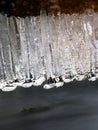 Winter creek with icicles above freeze mountain stream. Winter season Royalty Free Stock Photo