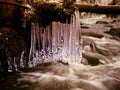 Winter creek with icicles above freeze mountain stream. Winter season Royalty Free Stock Photo