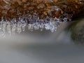 Winter creek with icicles above freeze mountain stream. Winter season Royalty Free Stock Photo