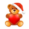 Winter cute baby brown teddy bear toy in sitting pose with red heart and in Santa Claus Christmas hat Royalty Free Stock Photo