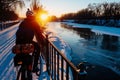 winter cyclist on bridge with sun setting over frozen river Royalty Free Stock Photo