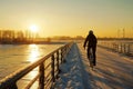 winter cyclist on bridge with sun setting over frozen river Royalty Free Stock Photo